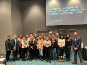 A group of people standing below a screen at the event in Iqualuit